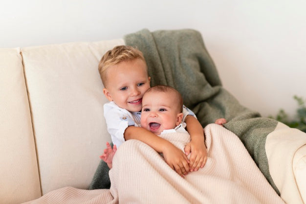 Happy toddler with his sibling