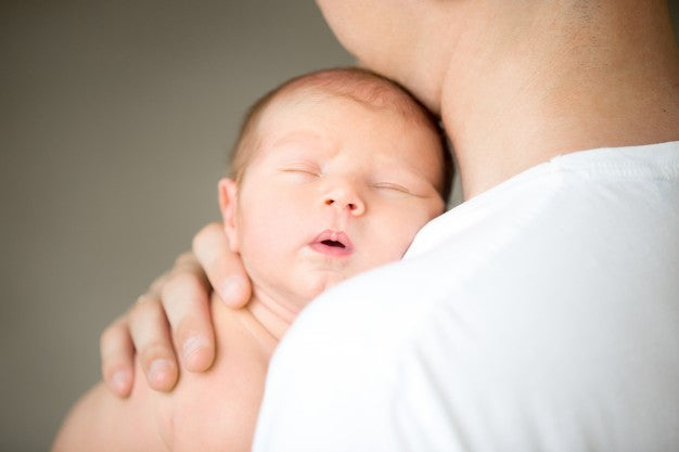 A cute little baby sleeping on shoulder